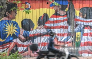 (Picture for representational purposes only). A motocyclist riding past a mural at Jalan Gereja in Kuala Lumpur. PIX: AFIQ HAMBALI / MalaysiaGazette / 07 NOVEMBER 2020 humanity brotherhood Malaysia flag children