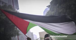 Israel crimes against humanity Palestine (Picture for representational purposes only.) A protestor flying the Palestine flag during the protest against the cruelty of Israel towards the Palestinians. PIX: HAZROL ZAINAL / MalaysiaGazette / 17 MAY 2021. war crime Gaza