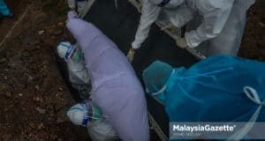 A Covid-19 body is laid to rest at the Section 21 Muslim Cemetery in Shah Alam, Selangor. PIX: MOHD ADZLAN / MalaysiaGazette / 20 MAY 2021. Petugas Kesihatan mengendalikan jenazah pesakit Covid-19 ketika tinjauan lensa Malaysia Gazette di Tanah Perkuburan Islam Seksyen 21, Shah Alam. Foto MOHD ADZLAN, 20 MEI 2021. Covid-19 death toll deaths