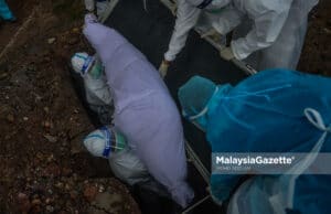 A Covid-19 body is laid to rest at the Section 21 Muslim Cemetery in Shah Alam, Selangor. PIX: MOHD ADZLAN / MalaysiaGazette / 20 MAY 2021. Petugas Kesihatan mengendalikan jenazah pesakit Covid-19 ketika tinjauan lensa Malaysia Gazette di Tanah Perkuburan Islam Seksyen 21, Shah Alam. Foto MOHD ADZLAN, 20 MEI 2021. Covid-19 death toll deaths