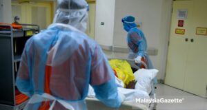 Healthcare worker transporting a Covid-19 patient to the ward at the Sungai Buloh Hospital in Selangor. PIX: FAREEZ FADZIL / MalaysiaGazette / 01 MARCH 2021 highest Covid-19 cases record