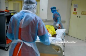 Healthcare worker transporting a Covid-19 patient to the ward at the Sungai Buloh Hospital in Selangor. PIX: FAREEZ FADZIL / MalaysiaGazette / 01 MARCH 2021 highest Covid-19 cases record