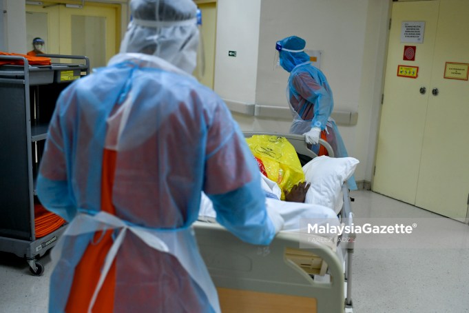 Healthcare worker transporting a Covid-19 patient to the ward at the Sungai Buloh Hospital in Selangor. PIX: FAREEZ FADZIL / MalaysiaGazette / 01 MARCH 2021 highest Covid-19 cases record