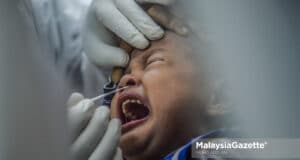 Picture for representational purposes onnly. A child is being screened for Covid-19 at the Paya Jaras State Assembly by a healthcare worker from Sel Care Selangor. PIX: MOHD ADZLAN / MalaysiaGazette / 26 MAY 2021. children UNICEF Malaysia