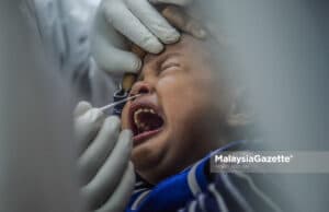 Picture for representational purposes onnly. A child is being screened for Covid-19 at the Paya Jaras State Assembly by a healthcare worker from Sel Care Selangor. PIX: MOHD ADZLAN / MalaysiaGazette / 26 MAY 2021. children UNICEF Malaysia