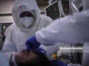Dr. Fadhli Suhaimi clad in Powered Air-Purifying Respirator (PAPR) while inspecting the respiratory support of a Covid-19 patient at the Intensive Care Unit (ICU) of the Kuala Lumpur Hospital. PIX HAZROL ZAINAL / MalaysiaGazette / 21 MAY 2020. deaths