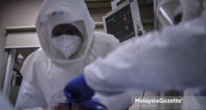 Dr. Fadhli Suhaimi clad in Powered Air-Purifying Respirator (PAPR) while inspecting the respiratory support of a Covid-19 patient at the Intensive Care Unit (ICU) of the Kuala Lumpur Hospital. PIX HAZROL ZAINAL / MalaysiaGazette / 21 MAY 2020. deaths