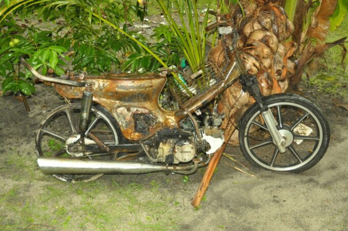 The torched motorcycle of an employee from a chicken processing factory.