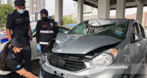 The Timur Laut District Police Chief, Assistant Commissioner Soffian Santong (centre) looks while the forensics team is inspecting the suspect’s vehicle feeling police