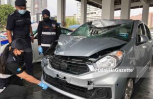 The Timur Laut District Police Chief, Assistant Commissioner Soffian Santong (centre) looks while the forensics team is inspecting the suspect’s vehicle feeling police