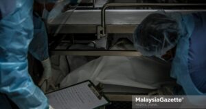 Healthcare workers from the Forensics Unit of the Sultanah Aminah Hospital in Johor managing the corpses in the cadaveric container freezer following the rise of Covid-19 deaths in the hospital. PIX: HAZROL ZAINAL / MalaysiaGazette / 06 JUNE 2021 Covid-19 deaths