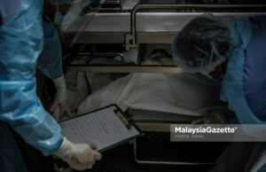 Healthcare workers from the Forensics Unit of the Sultanah Aminah Hospital in Johor managing the corpses in the cadaveric container freezer following the rise of Covid-19 deaths in the hospital. PIX: HAZROL ZAINAL / MalaysiaGazette / 06 JUNE 2021 Covid-19 deaths