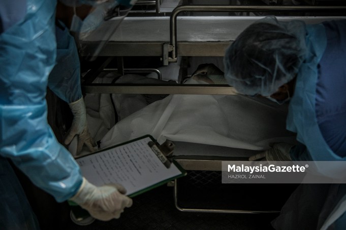 Healthcare workers from the Forensics Unit of the Sultanah Aminah Hospital in Johor managing the corpses in the cadaveric container freezer following the rise of Covid-19 deaths in the hospital. PIX: HAZROL ZAINAL / MalaysiaGazette / 06 JUNE 2021 Covid-19 deaths
