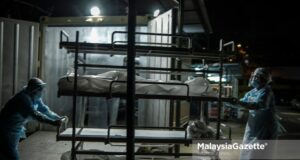 cadaveric container freezer Healthcare workers from the Forensics Unit of the Sultanah Aminah Hospital in Johor carry corpses into the cadaveric container freezer following the rise of Covid-19 deaths in the hospital. PIX: HAZROL ZAINAL / MalaysiaGazette / 06 JUNE 2021