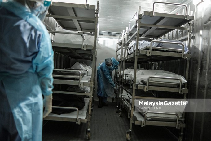 Healthcare workers from the Forensics Unit of the Sultanah Aminah Hospital in Johor managing the corpses in the cadaveric container freezer following the rise of Covid-19 deaths in the hospital.     PIX: HAZROL ZAINAL / MalaysiaGazette / 06 JUNE 2021