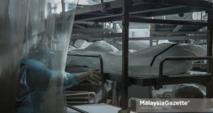 Healthcare workers from the Forensics Unit of the Sultanah Aminah Hospital in Johor place corpses into the cadaveric container freezer following the rise of Covid-19 deaths in the hospital. PIX: HAZROL ZAINAL / MalaysiaGazette / 06 JUNE 2021