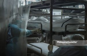 Healthcare workers from the Forensics Unit of the Sultanah Aminah Hospital in Johor place corpses into the cadaveric container freezer following the rise of Covid-19 deaths in the hospital. PIX: HAZROL ZAINAL / MalaysiaGazette / 06 JUNE 2021