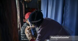 A resident from the Gombak Setia PPR in Kuala Lumpur receives his Covid-19 vaccine in the mobile vaccination centre in conjunction with the 'Vaksinasi COVID-19@Wilayah Prihatin' campaign at the Gombak Setia PPR Hall. PIX: AFFAN FAUZI / MalaysiaGazette / 12 JUNE 2021.