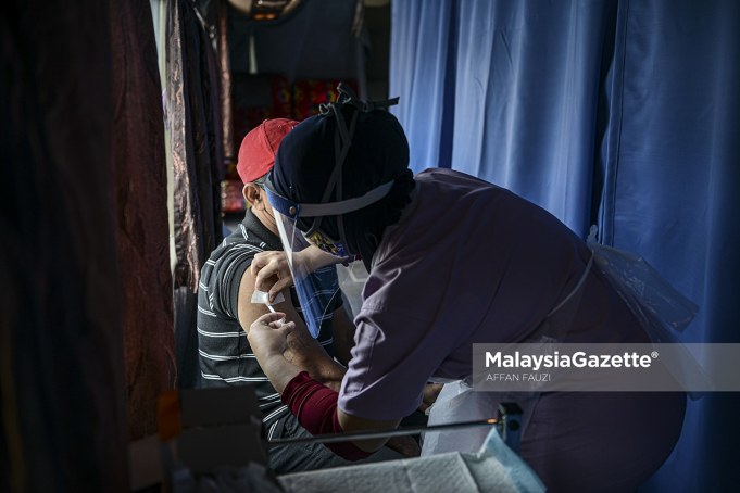 A resident from the Gombak Setia PPR in Kuala Lumpur receives his Covid-19 vaccine in the mobile vaccination centre in conjunction with the 'Vaksinasi COVID-19@Wilayah Prihatin' campaign at the Gombak Setia PPR Hall. PIX: AFFAN FAUZI / MalaysiaGazette / 12 JUNE 2021.