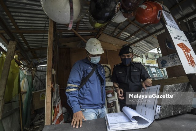 Dang Wangi District Police Chief, Assistant Commissioner Mohamad Zainal Abdullah inspects the documentation at a construction site during the Full MCO SOP Compliance Operation.     PIX: HAZROL ZAINAL / MalaysiaGazette / 19 JUNE 2021.
