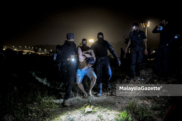 An illegal immigrant who tried to flee is arrested by the Department of Immigration during an integrated operation at a construction site in Dengkil, Selangor.        PIX: AFFAN FAUZI / MalaysiaGazette / 21 JUNE 2021