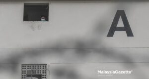 (Picture for representational purposes only). A resident of the Desa Rejang Flat in Kuala Lumpur looking out of a window after the Enhanced Movement Control Order (EMCO) is implemented on the flat. PIX: SYAFIQ AMBAK / MalaysiaGazette / 23 JUNE 2021