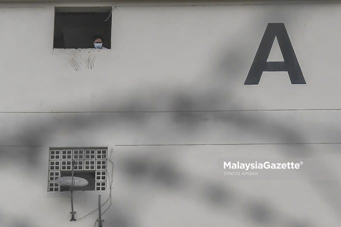 (Picture for representational purposes only). A resident of the Desa Rejang Flat in Kuala Lumpur looking out of a window after the Enhanced Movement Control Order (EMCO) is implemented on the flat. PIX: SYAFIQ AMBAK / MalaysiaGazette / 23 JUNE 2021