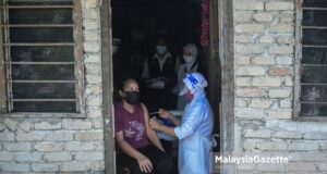 fully vaccinated Healthcare worker providing the Sinovac Covid-19 vaccine shot to the Orang Asli from the Jakun Tribe at the Gumum Orang Asli Village in Chini, Pahang. PIX: HAZROL ZAINAL / MalaysiaGazette / 25 JUNE 2021