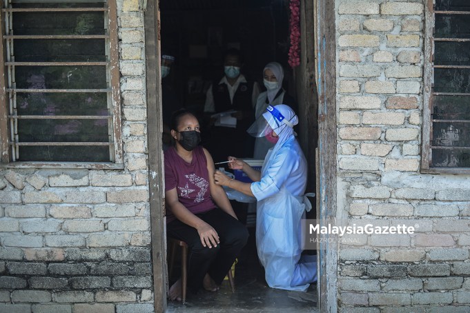fully vaccinated Healthcare worker providing the Sinovac Covid-19 vaccine shot to the Orang Asli from the Jakun Tribe at the Gumum Orang Asli Village in Chini, Pahang. PIX: HAZROL ZAINAL / MalaysiaGazette / 25 JUNE 2021