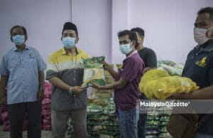 Temubual bersama Pengerusi Persatuan Penduduk Kampung Selayang Lama, Mohammed Sharif Abdul Rahman (dua kiri) diiringi Naib Presiden Pertubuhan Produk Ummah Malaysia, Razali Latiff (kiri) menyerahkan sumbangan kepada wakil penduduk di Selayang, Kuala Lumpur. Foto HAZROL ZAINAL, 27 JUN 2021.