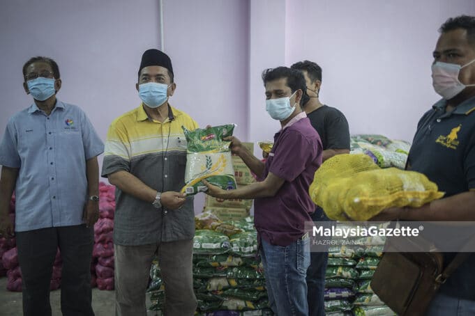 Temubual bersama Pengerusi Persatuan Penduduk Kampung Selayang Lama, Mohammed Sharif Abdul Rahman (dua kiri) diiringi Naib Presiden Pertubuhan Produk Ummah Malaysia, Razali Latiff (kiri) menyerahkan sumbangan kepada wakil penduduk di Selayang, Kuala Lumpur. Foto HAZROL ZAINAL, 27 JUN 2021.