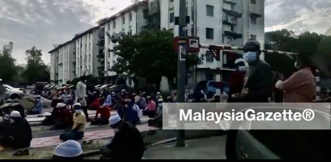 A screenshot of the hundreds of foreigners performing Aidiladha prayer on the road at Taman Pelangi, Juru.