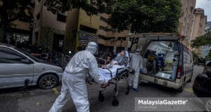 Healthcare workers carrying out Covid-19 patient from PPR Kampung Baru Air Panas in Kuala Lumpur after the area is put on Enhanced Movement Control Order (EMCO). PIX: AFFAN FAUZI / MalaysiaGazette / 03 JULY 2021. Covid-19 cases