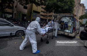 Healthcare workers carrying out Covid-19 patient from PPR Kampung Baru Air Panas in Kuala Lumpur after the area is put on Enhanced Movement Control Order (EMCO). PIX: AFFAN FAUZI / MalaysiaGazette / 03 JULY 2021. Covid-19 cases
