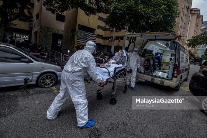 Healthcare workers carrying out Covid-19 patient from PPR Kampung Baru Air Panas in Kuala Lumpur after the area is put on Enhanced Movement Control Order (EMCO). PIX: AFFAN FAUZI / MalaysiaGazette / 03 JULY 2021. Covid-19 cases