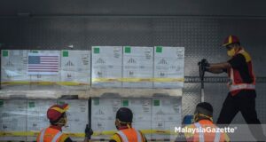 DHL delivery staff handling the freshly arrived 1 million doses of Pfizer BioNTech Covid-19 vaccine contributed by the United States of America for the Malaysians. PIX: HAZROL ZAINAL / MalaysiaGazette / 05 JULY 2021