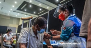 Healthcare worker administering Covid-19 vaccine on a person with disability at the UCSI University, Cheras vaccination centre. PIX: MOHD ADZLAN / Malaysiagazette / 07 JULY 2021. doses vaccination