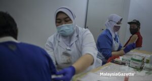 fully vaccinated adult population Healthcare workers preparing to administer the Covid-19 vaccine for the homeless during the Covid-19 Vaccination Programme Gelandangan@WPKL at Anjung Kelana, Kuala Lumpur. PIX: HAZROL ZAINAL / MalaysiaGazette / 17 JUNE 2021 covid-19 cases fake vaccine certs