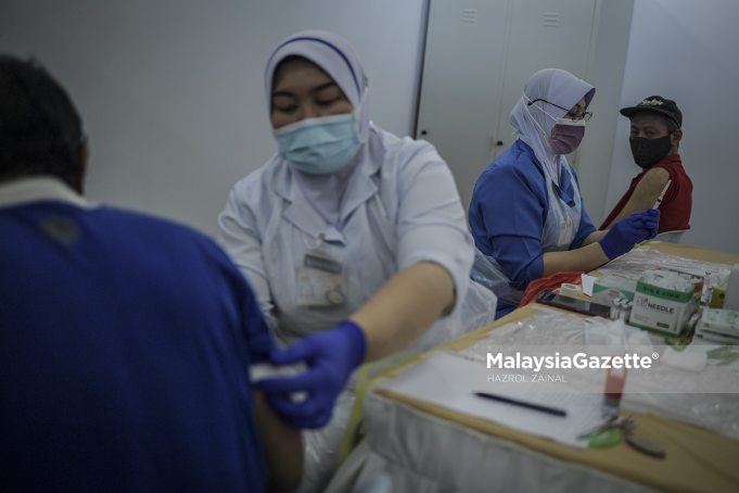 fully vaccinated adult population Healthcare workers preparing to administer the Covid-19 vaccine for the homeless during the Covid-19 Vaccination Programme Gelandangan@WPKL at Anjung Kelana, Kuala Lumpur. PIX: HAZROL ZAINAL / MalaysiaGazette / 17 JUNE 2021 covid-19 cases fake vaccine certs