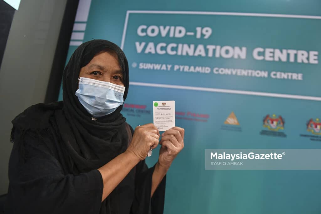 Warga emas, Azizah Ahmad, 67, menunjukkan kad vaksinasi Covid-19 selepas hadir secara “walk in” untuk menerima suntikan vaksin di Pusat Pemberian Vaksin (PPV) Sunway Pyramid, Selangor. Foto SYAFIQ AMBAK, 17 JULAI 2021.