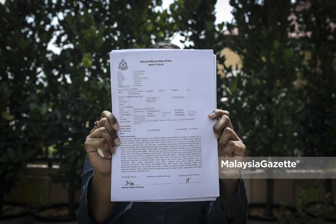    Yositha shows the police report she has lodged on the domestic violence she has endured.     PIX: HAZROL ZAINAL / MalaysiaGazette / 18 JULY 2021