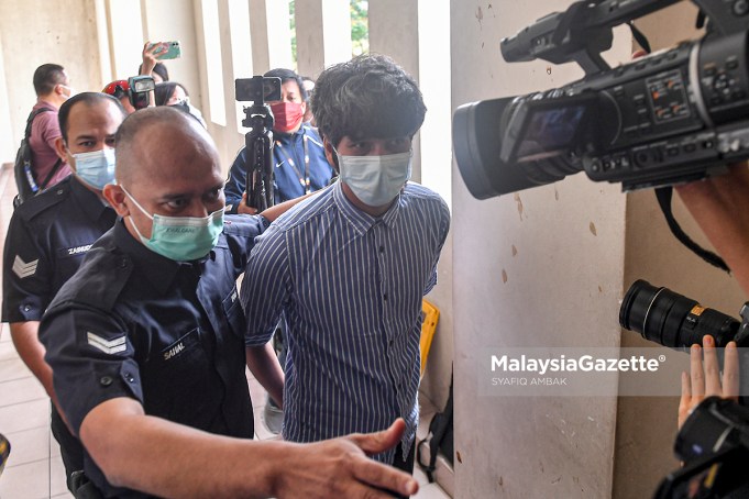 Police escort controversial film producer of ‘Babi’, Toh Han Boon, 35, to the Petaling Jaya Magistrate Court to be charged for distributing and displaying film poster without valid license. PIX: SYAFIQ AMBAK / MalaysiaGazette / 21 JULY 2021.