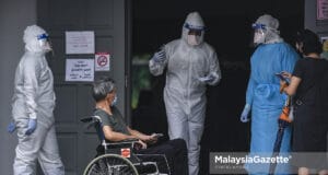 An individual suspected to be Covid-19 positive arrives at the Bandar Tun Razak Covid-19 Assessment Centre (CAC) in Kuala Lumpur to get her health screening. PIX: SYAFIQ AMBAK / MalaysiaGazette / 25 JULY 2021. Orang awam yang disyaki positif Covid-19 hadir seawal pagi bagi melakukan penilaian kesihatan di Pusat Penilaian COVID-19 (CAC), Kompleks Sukan Bandar Tun Razak, Kuala Lumpur. Foto SYAFIQ AMBAK, 25 JULAI 2021. Hybrid CAC