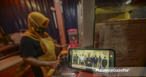 Trader, Ismail Jusoh watching the live telecast of Prime Minister Tan Sri Muhyiddin Yassin’s special address on seeking bipartisan support at Jalan Raja Bot, Kuala Lumpur. PIX: AFFAN FAUZI / MalaysiaGazette / 13 AUGUST 2021 anti-party hopping law two terms PM bipartisan support government