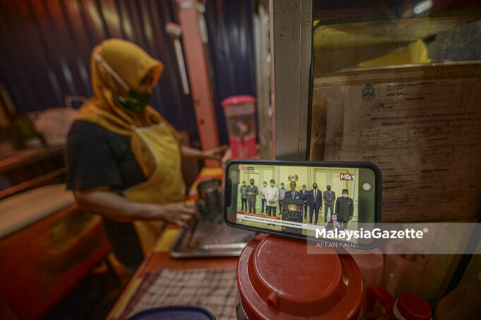 Trader, Ismail Jusoh watching the live telecast of Prime Minister Tan Sri Muhyiddin Yassin’s special address on seeking bipartisan support at Jalan Raja Bot, Kuala Lumpur. PIX: AFFAN FAUZI / MalaysiaGazette / 13 AUGUST 2021 anti-party hopping law two terms PM bipartisan support government
