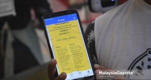 fully vaccinated A customer showing the digital vaccination certification before entering a barbershop to get his haircut after the government allows hair salons & barbershops to operate during Phase 1 of National Development Plan (PPN). PIX: SYAFIQ AMBAK / Malaysiagazette / 16 AUGUST 2021.