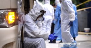 Petugas Kementerian Kesihatan Malaysia (KKM) dilihat keletihan selepas membawa keluar warga asing menaiki bas dan van untuk dibawa ke pusat kuarantin ketika tinjauan lensa Malaysia Gazette di kawasan tapak pembinaan di Jalan Ampang, Kuala Lumpur. foto SYAFIQ AMBAK, 26 MEI 2020 COvid-19 record