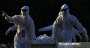 Healthcare workers managing Covid-19 bodies at the Bukit Kiara Muslim Cemetery in Kuala Lumpur. PIX: SYAFIQ AMBAK / MalaysiaGazette / 27 JULY 2021. Covid-19 death fully vaccinated Covid-19 deaths