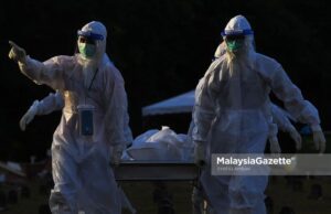 Healthcare workers managing Covid-19 bodies at the Bukit Kiara Muslim Cemetery in Kuala Lumpur. PIX: SYAFIQ AMBAK / MalaysiaGazette / 27 JULY 2021. Covid-19 death fully vaccinated Covid-19 deaths