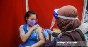 Healthcare worker injecting the Pfizer-BioNTech Covid-19 vaccine on a secondary school student during the National Covid-19 Immunisation Programme for Adolescents (PICK-A) at the Management and Science University (MSU) in Shah Alam. PIX: MOHD ADZLAN / MalaysiaGazette / 20 SEPTEMBER 2021.